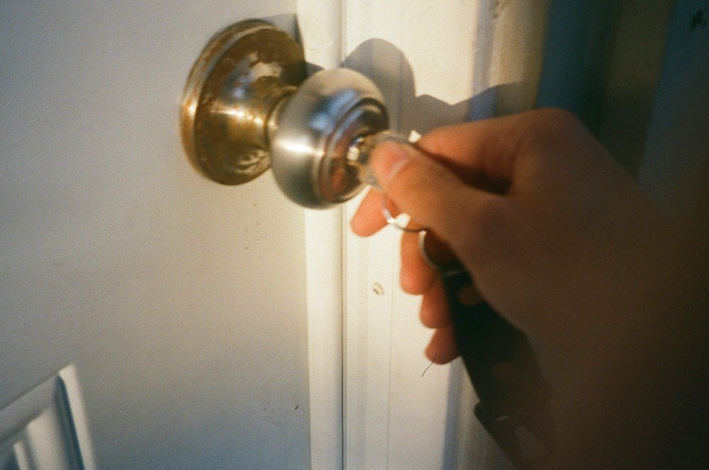 Main tournant une clé dans la poignée d'une porte lors d'un dépannage de serrure